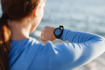 Runner woman with heart rate monitor running on beach