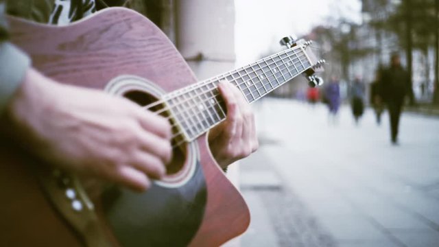 A man plays guitar on the street
