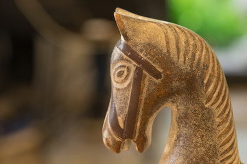 Craving wooden head horse toy / Craving wooden head horse toy on wooden table in evening with sun shine on left face 