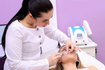 Beautiful woman gets an injection in her lips.