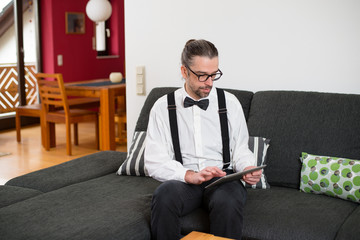 Fototapeta premium bearded man in white shirt with bow-tie with tablet PC