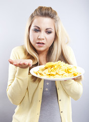 Young girl with potato chips. She thinks. Blonde watch your diet
