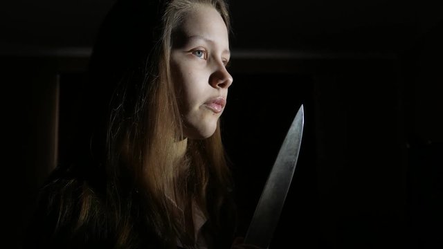 Teen girl with a big knife, horror movie dark scene, 4K UHD