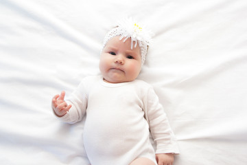 Little newborn girl lying on the bed 
