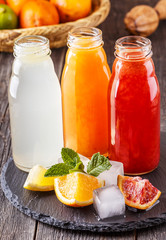 Fresh citrus juices on a dark wooden background.