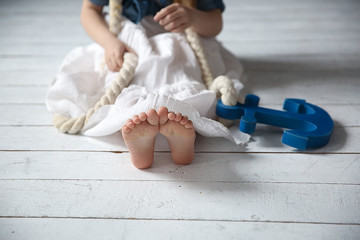 Little girl with rope and anchor in her hands