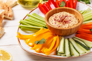 Homemade hummus with assorted fresh vegetables and pita bread.