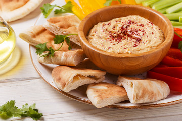 Homemade hummus with assorted fresh vegetables and pita bread.