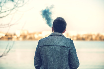Fototapeta premium Man with beard vaping outdoor electronic sigarette