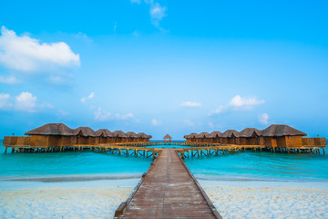 Fototapeta na wymiar Over water bungalows with steps into amazing green lagoon 