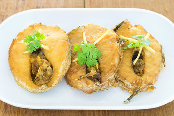 Fried fish on a white plate, Wooden background