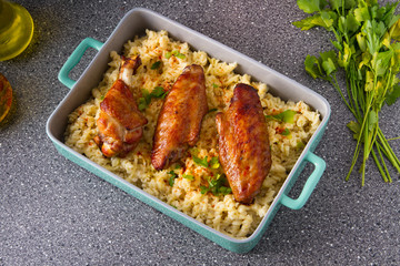 Baked spicy wings of turkey with cheese noodles.