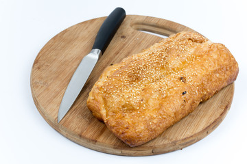 Puff pastry on the wooden kitchen board with knife