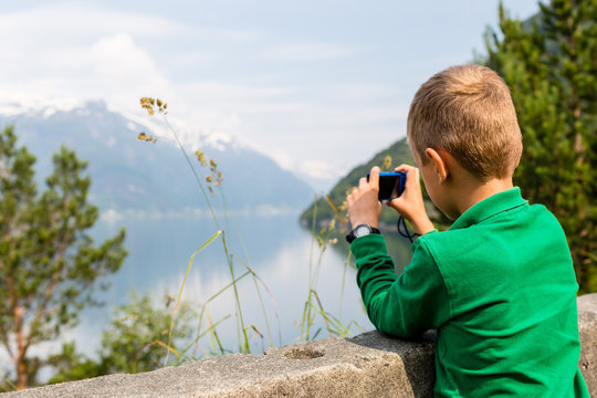 Boy taking picture with digital compact camera