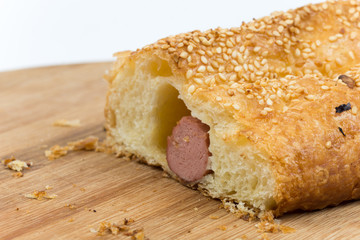 Sliced sausage roll on the wooden kitchen board