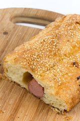 Sliced sausage roll on the wooden kitchen board