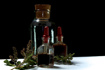 Obraz na płótnie Canvas three glass bottles with herbal extracts and dried herbs close t