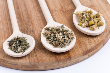 Chamomile tea nettle and basil on a wooden spoon