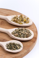 Chamomile nettle and basil tea on a wooden spoon