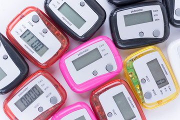 Pile of colorful pedometers over white background