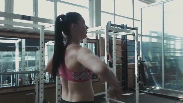 The strong woman prepares for training to competitions in a gym