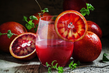 Juice of blood orange in a large glass, decorated with a slice o