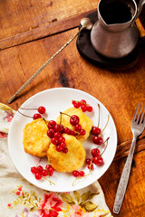 Light breakfast from cheesecakes with fresh berries and hot coffee on the table