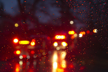 Emergency Vehicles Flashing Through a Wet Windshield Darkly