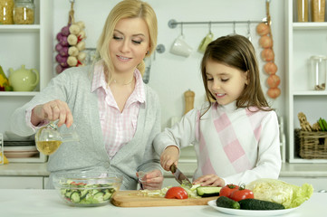 mother and daughter cooking  in kitchen