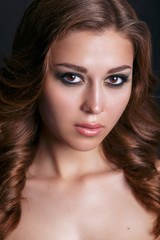 Fototapeta premium Fashion portrait of young beautiful sexy woman with long wavy hair. Beauty Model Woman with Long Brown Hair. Healthy Hair and Beautiful Professional Makeup. Smoky Eyes Make up. Gorgeous Woman Face