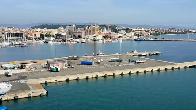 The Island of Sardinia. Panorama of The Port and The Coastal Part of The City of Cagliari From The Deck of a Cruise Ship. Sunny Day, Blue Mediterranean Sea.