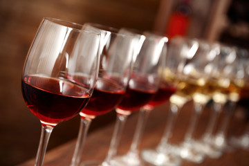 Many glasses of different wine in a row on bar counter