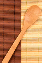 wooden spoon lying on a diagonal on two mats