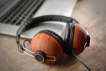 Obraz na płótnie Canvas Laptop and earphones on wooden background