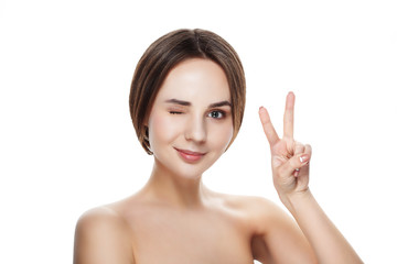Obraz na płótnie Canvas Pretty girl with natural makeup show gesture VICTORY. Beautiful spa woman touching her face. Perfect fresh skin. Pure beauty model girl. Youth and skin care concept