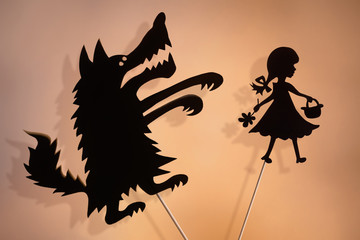 Little Red Riding Hood and the Big Bad Wolf shadow puppets and their shades on the soft glowing...