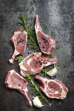 Raw Lamb Cutlets with Herbs on Slate Overhead View