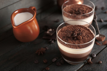 Delicious dessert with chocolate powder and coffee beans in glass