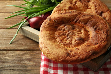 Fresh fried bread with onion on wooden table closeup