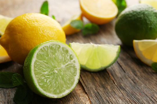Sliced fresh lemons and lime on wooden table closeup