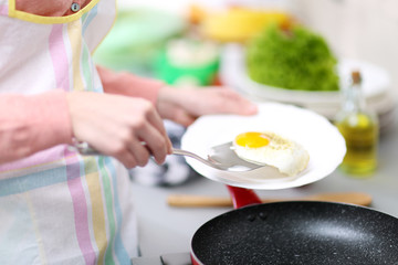 Female hands lay down egg on plate, closeup
