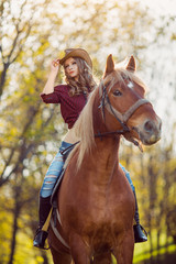 Fototapeta premium Beautiful girl riding horse on autumn field