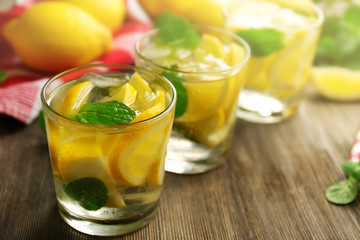 Composition of lemonades,  lemons and mint on wooden table background, closeup