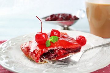 Cherry strudel with mint and cup of coffee
