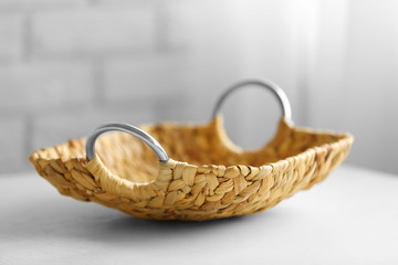 Wicker salver with metal handles on wooden table background, closeup