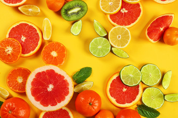 Fototapeta na wymiar Set of sliced citrus fruit on yellow background