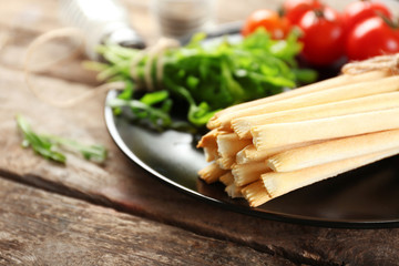 Bread sticks with arugula and cherry tomatoes on plate