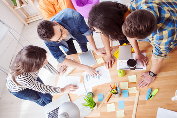 Cheerful four colleagues are discussing their work