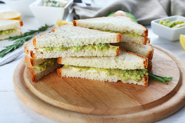 Avocado sandwiches with lemon on cutting board