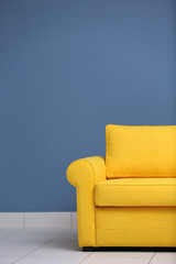 Yellow sofa on a blue wall background